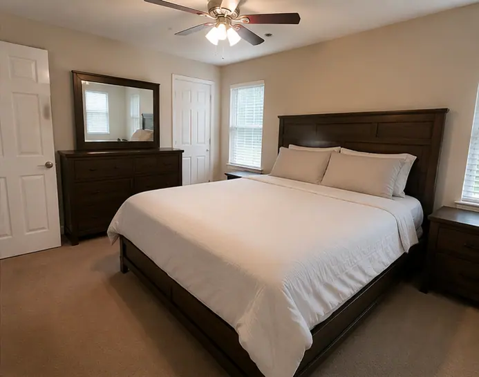 Neatly made bed and clear surfaces in a Dallas bedroom after a monthly cleaning visit