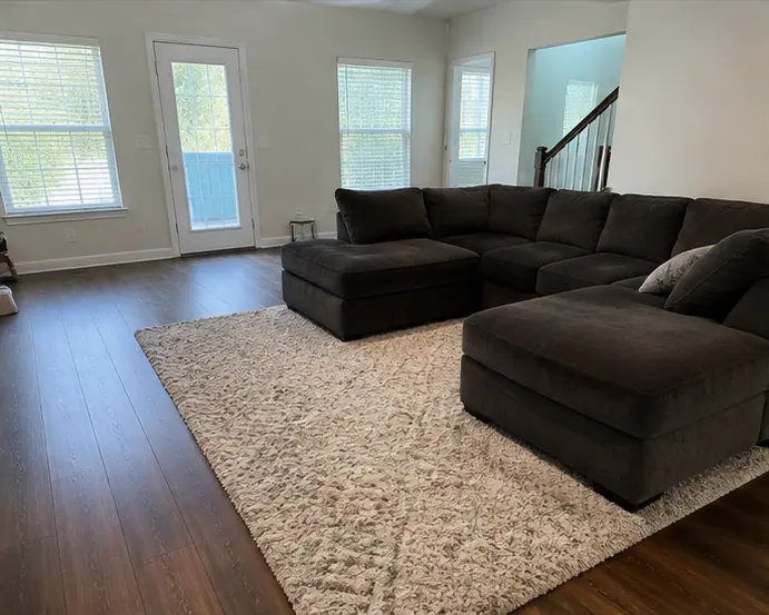 Townhome living area in Dallas with staircase and sectional after cleaning